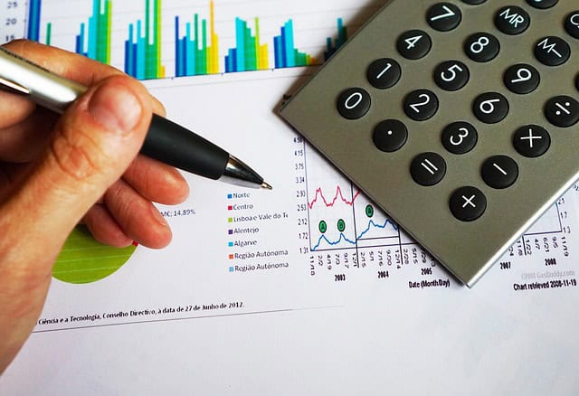 Analyse financière avec calculatrice et graphiques de données économiques.