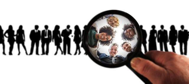 Groupe de personnes d'affaires sous une loupe, concept de recrutement et de sélection.