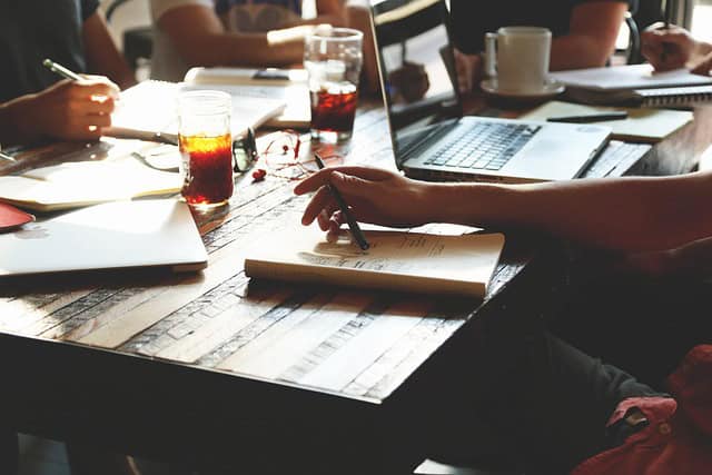 Réunion de groupe pour formation NDRC avec ordinateurs et notes.