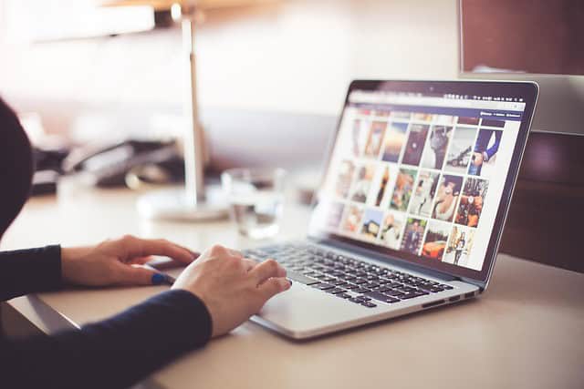 Person utilisant un ordinateur portable pour rechercher des formations NDRC en ligne.