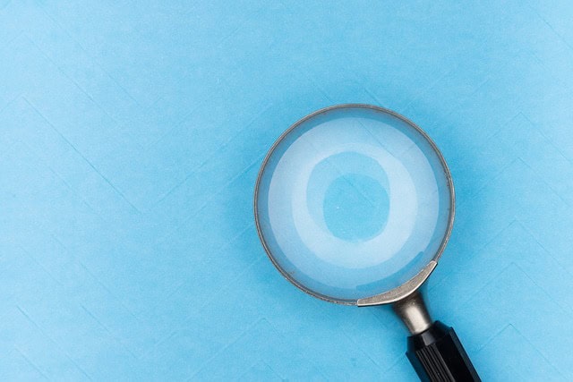 Loupe de microscope sur fond bleu pour la formation NDRC.