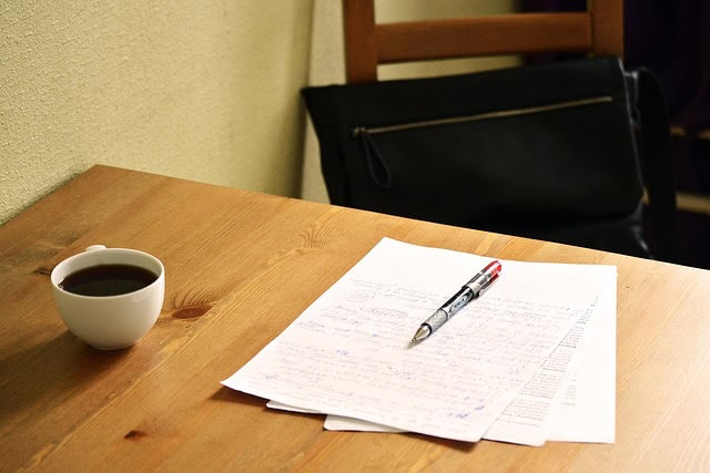 Étude pour formation NDRC avec documents et café sur une table en bois.