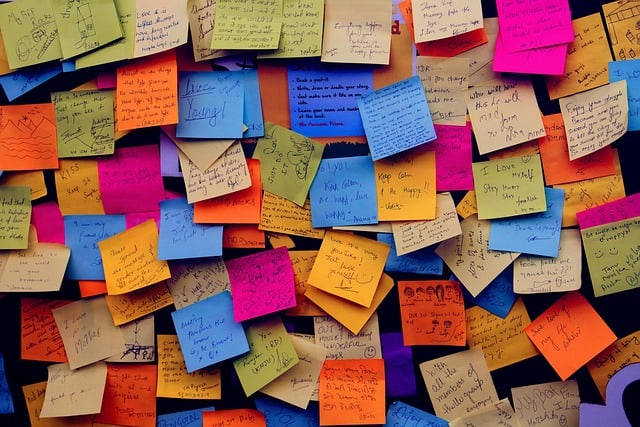 Notes colorées et post-it sur un mur, symbolisant la créativité et l'organisation.